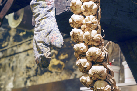 Old white garlic hung in an old kitchen since a lot of time ago.の写真素材