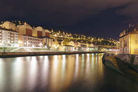 View at night of the city of Bilbao, Basque Country, Spain. Olabeaga and Zorrozaurre districts separated by the Nervion river. Long exposure shot.の写真素材