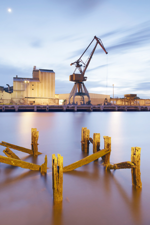 View at evening of the Nervion river near the city of Bilbao, Basque Country, Spain. Industrial port area with crane and factory in the district of Zorroza.の写真素材