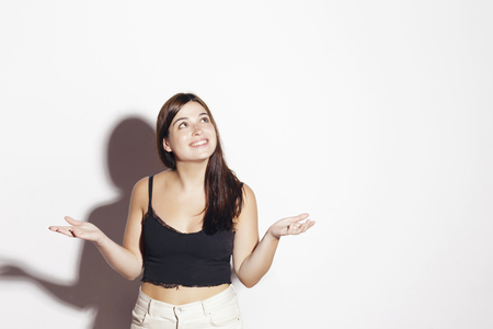 Cheerful brunette girl, looking up. Fortune concept. Over a white background.の写真素材