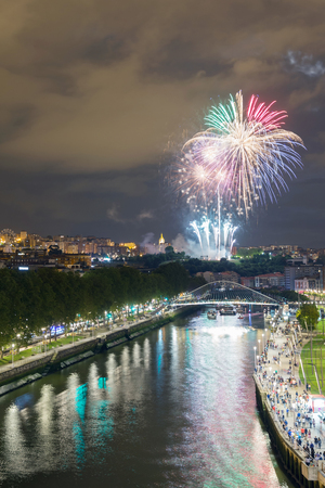 Landscape of the city of Bilbao at night. Fireworks from the annual city festivities.の写真素材