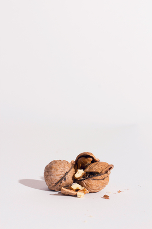 Walnuts and a hammer, on a white surface. Risk and break concept.