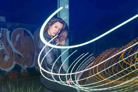 Brunette woman alone in the street. Outdoors at night.の写真素材
