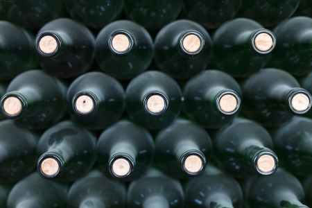 Dusty stacked wine bottles with their corresponding corksの写真素材