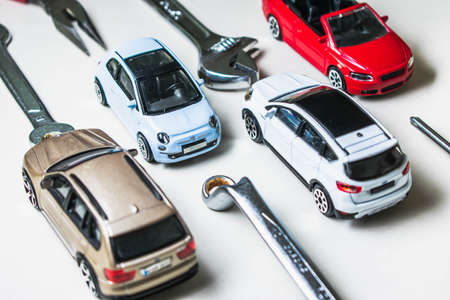 Toy car and tools on a white background. The concept of buying a car.