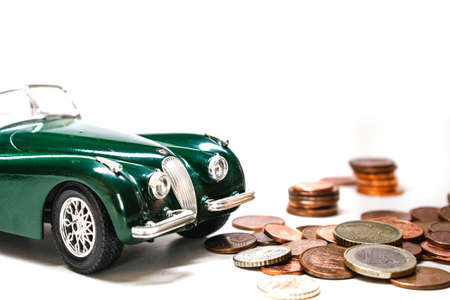 Coins and toy car on a white background with copy space.の写真素材