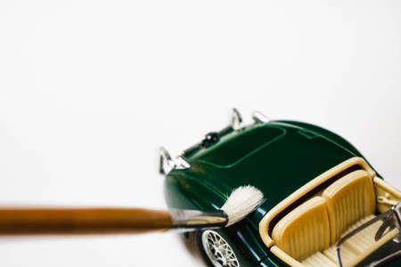 Close-up of a green toy car with a brush on a white backgroundの写真素材
