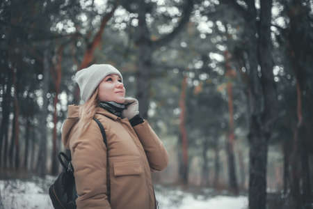 Young blonde woman walks in the winter forest.の写真素材