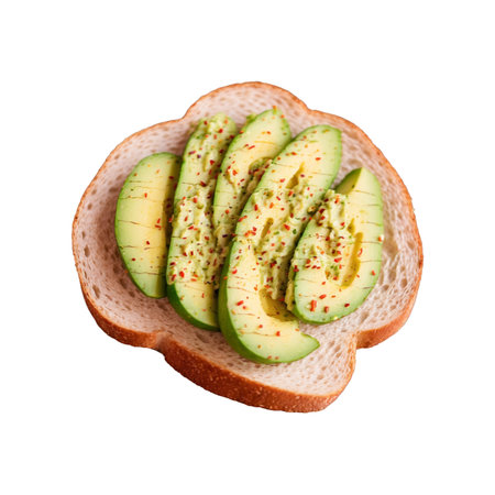 Closeup shot of avocado toast featuring ripe avocado slices with red pepper flakes on a slice of white bread, presented on a white background for clean presentation.の素材