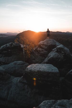 A tourist guy and beautiful morning sunrise of the Mariina Viewpoint, Bohemian Switzerland, National Park Bohemian Switzerland, Czech republicの写真素材