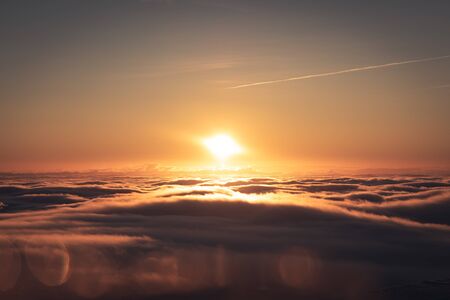 Winter landscape in Krkonose, beautiful sunrise with moon above the heavy clouds, shot from highest mountain in Czech republic called Snezka.の写真素材