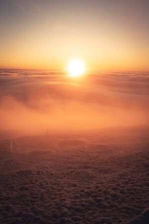Winter landscape in Krkonose, beautiful sunrise with moon shot from highest mountain in Czech republic called Snezka.の写真素材