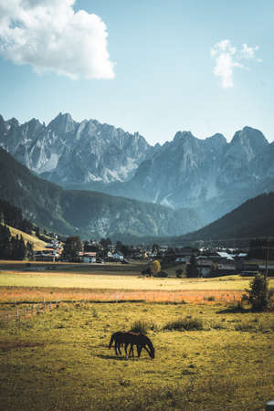 Beautiful view of idyllic mountain scenery in the Dolomites with mountain village on a sunny day with blue sky and clouds in spring, Val di Funes, South Tyrol, northern Italyの写真素材