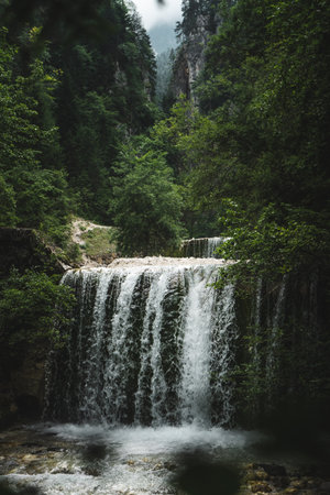 A waterfall, hidden behind hills, deep inside the Martuljek Forest in the Triglav National Park in Slovenia. Its name is Martuljek waterfall-Martuljski slap.の写真素材