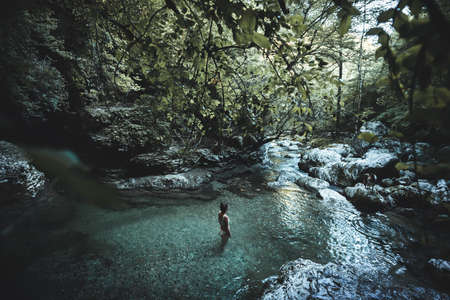 Young woman standing in pure clear lagoon in Slovenia national park, Triglavの写真素材