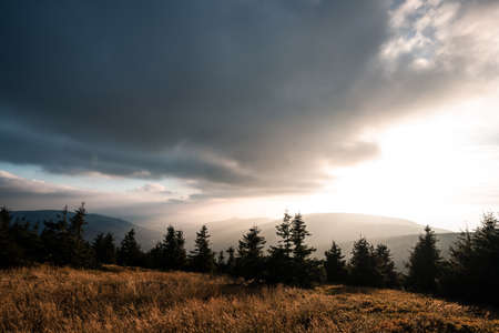 Landscape of warm light sun rays on sky through the clouds over the mountains in Czech republic, Jesenikyの写真素材