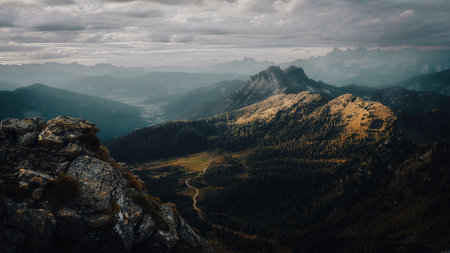 Enjoying a scenic view of a spectacular mountain range that is beautifully framed by a cloudy sky overhead, creating a breathtaking backdropの写真素材