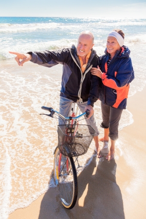 seniors with bicycle outdoors in autumnの写真素材