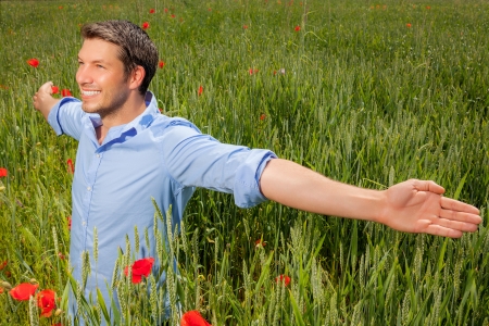 carefree male in green poppy fieldの写真素材