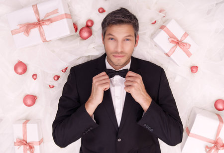 elegant male with gift lying downの写真素材