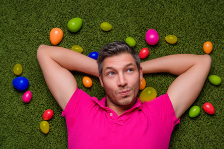 man lying green grass springtime with easter eggs