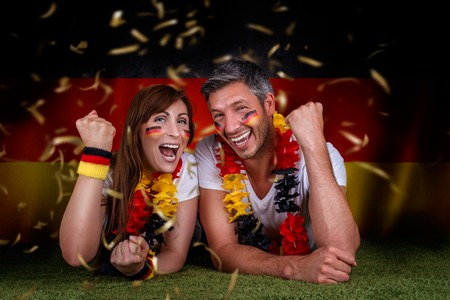 happy funny german couple rising armsの写真素材
