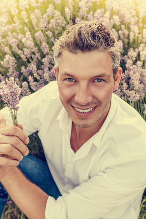 man sitting on flower meadowの写真素材