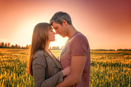 deep sunset in a field with man and girlの写真素材