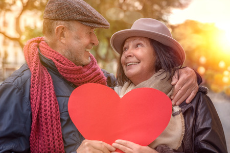 heart holding senior couple in the cityの写真素材