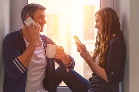 modern couple on phones while coffeeebreaktの写真素材