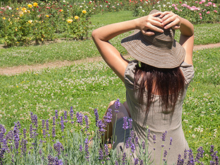 fine woman sitting on the green grass in summer dayの写真素材