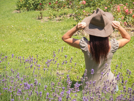 beautiful long hair woman sitting on the green parkの写真素材