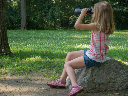 young girl with black binocularsの写真素材