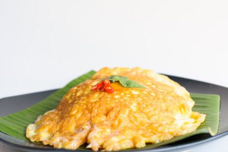 spicy omelet  on banana leaf in black dishの写真素材