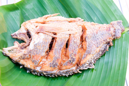 deep fried fish on green banana leaf top viewの写真素材