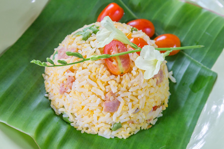Fried rice with tomato and pork on banana leaf in dishの写真素材