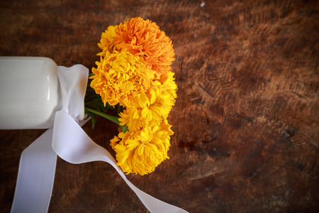 marigolds in white vase on old woodenの写真素材