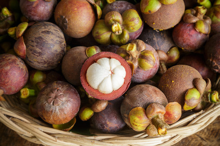 fresh mangosteen fruit and cross section in basket
