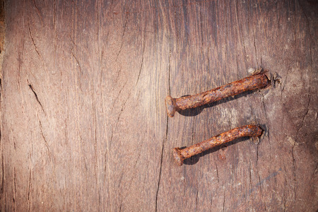 Rusted nails sticking on old wooden backgroundの写真素材