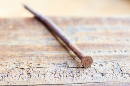 Rusted nails sticking on old wooden backgroundの写真素材