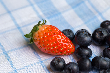 Fresh ripe red strawberries and blueberries in sieveの写真素材