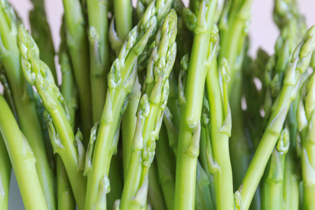 Fresh green asparagus for cooking on chopping blockの写真素材