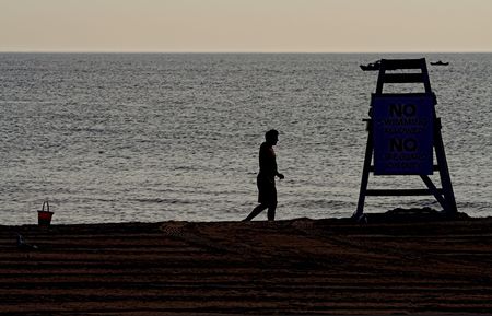sihlouette of lonely man and lifeguard tower on beachの写真素材