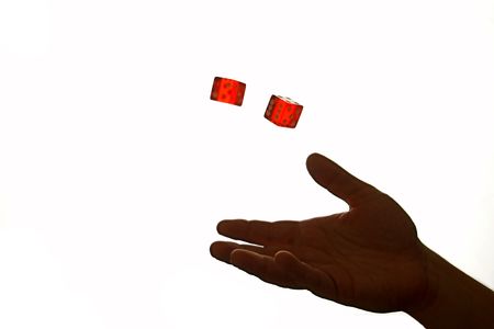 hands tossing two red dice in the airの写真素材