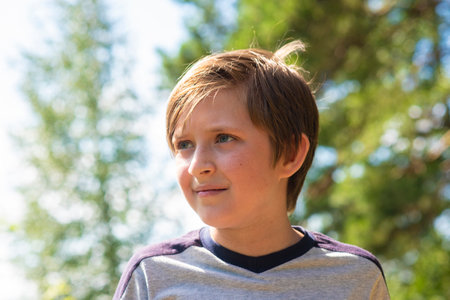 Portrait of a boy in a park on a sunny day.