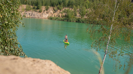 A girl in a kayak on the bank of a mountain riverの写真素材