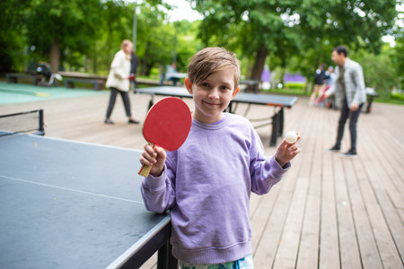 Boy playing table tennis in the park. Selective focus on boyの写真素材