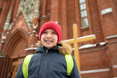 Portrait of a boy in a warm jacket and hat in the winter parkの写真素材