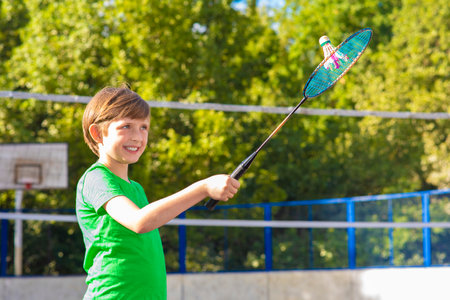 Little boy hanging upside down on a pole in a summer park.の写真素材