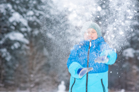 Adorable little boyl having fun on beautiful winter day. Cute child playing outdoors. Winter activities for kids.の写真素材